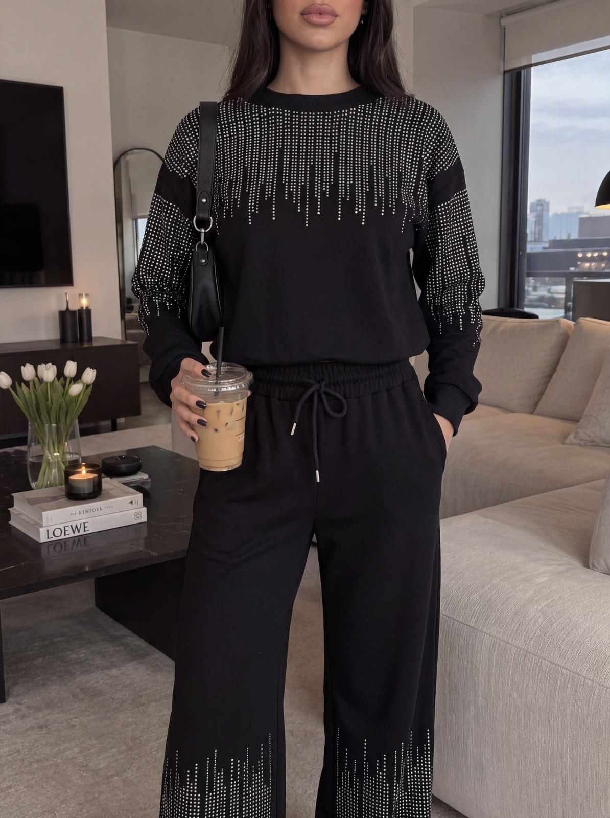 Rhinestone embellishment cascading from the shoulders of a black set.