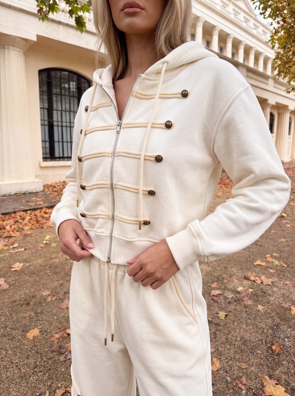 Close view of a cream hooded set with cord and button trim.