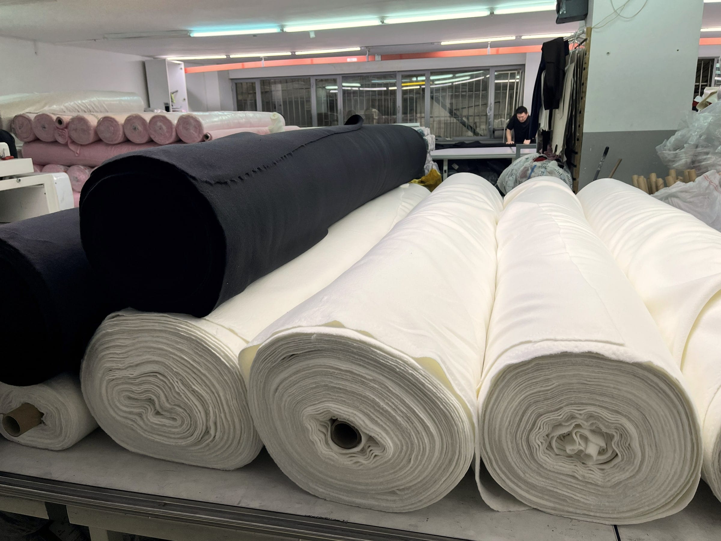 Cream and black fabric rolls on the cutting table.